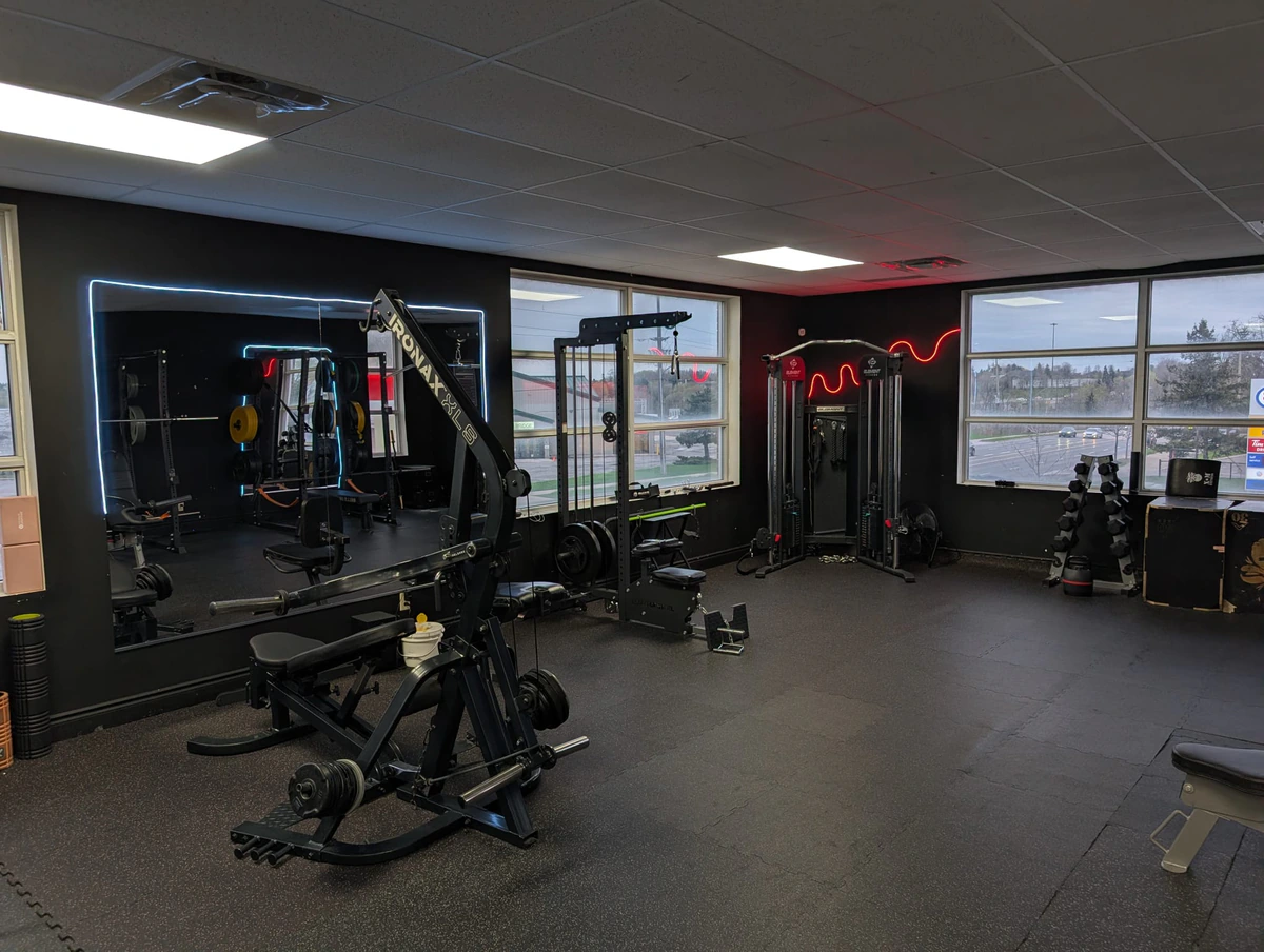 Mirror room with leverage machine and cable station at Retraine, a private training studio in Pickering.